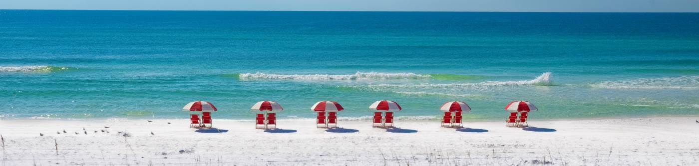 Beach Scene with Red Chairs and Red Umbrellas
